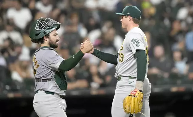 Oakland Athletics relief pitcher Mason Miller, right, and catcher Shea Langeliers celebrate after the team's 2-0 shutout of the Chicago White Sox in a baseball game Friday, Sept. 13, 2024, in Chicago. (AP Photo/Charles Rex Arbogast)