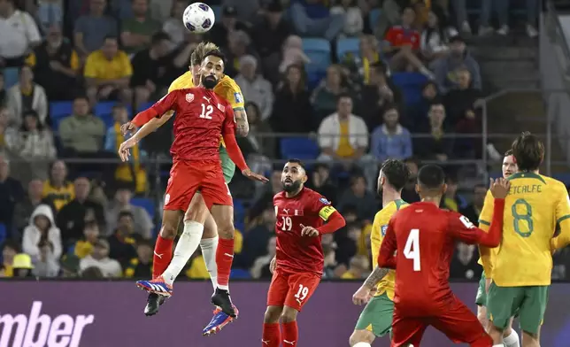 Bahrain's Mahdi Abduljabbar Mahdi Darwish Hasan, front left, competes with Australia's Harry Souttar for a high ball during their World Cup 2026 qualifying match at the Gold Coast, Australia, Thursday, Sept. 5, 2024. (Dave Hunt/AAP Image via AP)