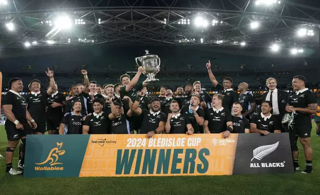 New Zealand celebrate with the bLedisloe Cup after their win over Australia in rugby union test match in Sydney, Saturday, Sept. 21, 2024. (AP Photo/Rick Rycroft)