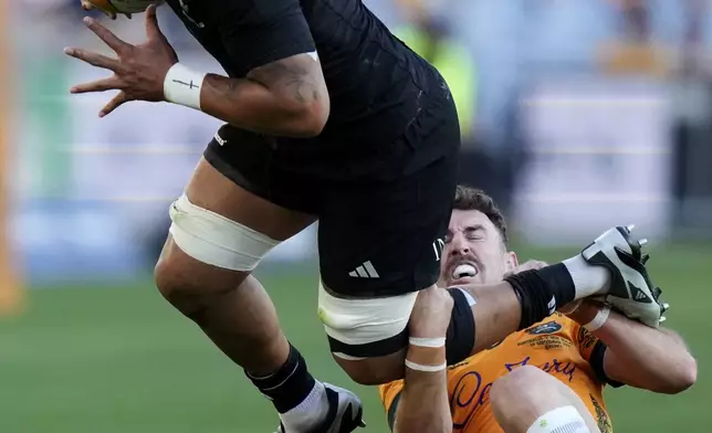 New Zealand's Ardie Savea, left, is tackled by Australia's Nic White during their rugby union test match in Sydney, Saturday, Sept. 21, 2024. (AP Photo/Rick Rycroft)