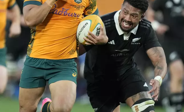 Australia's Len Ikiau, left, races away from New Zealand's Ardie Savea during their rugby union test match in Sydney, Saturday, Sept. 21, 2024. (AP Photo/Rick Rycroft)