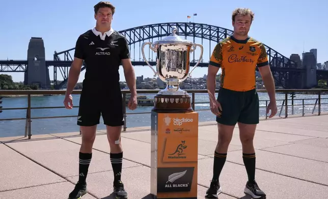 Australia captain Harry Wilson, right, and New Zealand skipper Scott Barrett, left, pose with the Bledisloe Cup in Sydney, Friday, Sept. 20, 2024, ahead of their rugby union test match Saturday. (AP Photo/Rick Rycroft)