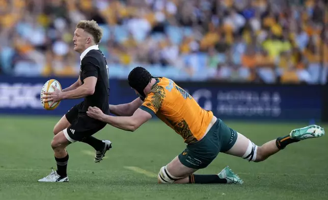 New Zealand's Damian McKenzie, left, is tackled by Australia's Nick Frost during their rugby union test match in Sydney, Saturday, Sept. 21, 2024. (AP Photo/Rick Rycroft)