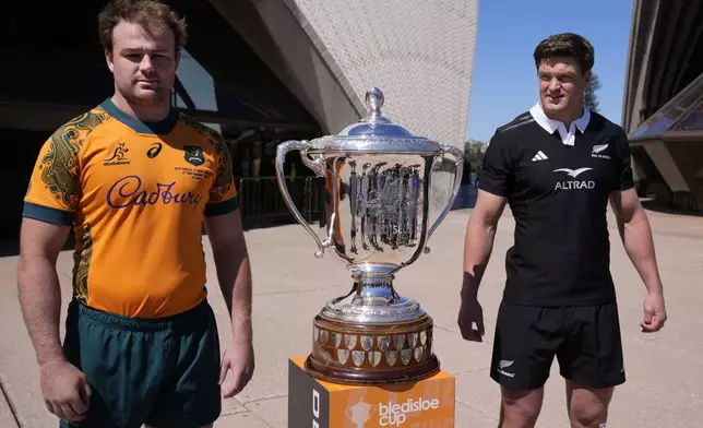 Australia captain Harry Wilson, left, and New Zealand skipper Scott Barrett, right, pose with the Bledisloe Cup in Sydney, Friday, Sept. 20, 2024, ahead of their rugby union test match Saturday. (AP Photo/Rick Rycroft)