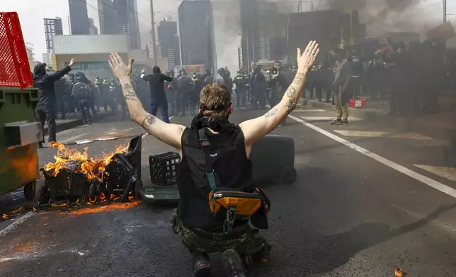 A protester gestures to Victorian police at an anti-war protest outside a military arms convention in downtown Melbourne, Australia, Wednesday, Sept. 11, 2024. (Con Chronis/AAP Image via AP)