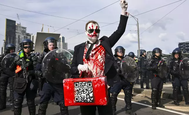 A protester gestures as Victorian police clash with anti-war protesters outside a military arms convention in downtown Melbourne, Australia, Wednesday, Sept. 11, 2024. (Joel Carrett/AAP Image via AP)