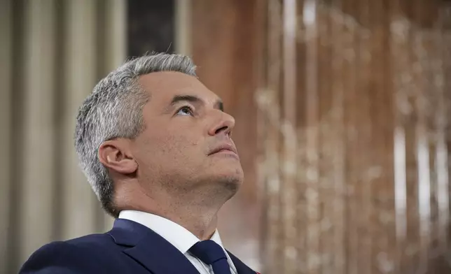 Austrian Chancellor Karl Nehammer looks up while attending a debate at the national broadcaster studio, set up in the parliament building, in Vienna, Austria, Sunday, Sept. 29, 2024, after polls closed in the country's national election. (AP Photo/Heinz-Peter Bader)