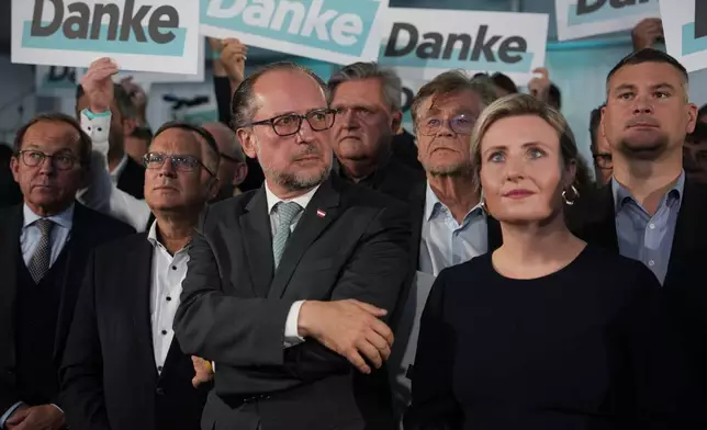 Austria's Foreign Minister Alexander Schallenberg, center left, and Susanne Raab of the at the OVP, Austrian People's Party, look on as supporters hold "Thank You" banners at the party headquarters in Vienna, Austria, Sunday, Sept. 29, 2024, after seeing the first electoral projections in the country's national election. (AP Photo/Andreea Alexandru)