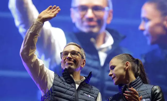 Head of the Freedom Party (FPOE) Herbert Kickl, left, waves to supporters besides party colleague Susanne Fuerst after his speech at a final election campaign event at St. Stephen's square in Vienna, Austria, Friday, Sept. 27, 2024, ahead of the country's national election which will take place on Sept. 29. (AP Photo/Heinz-Peter Bader)