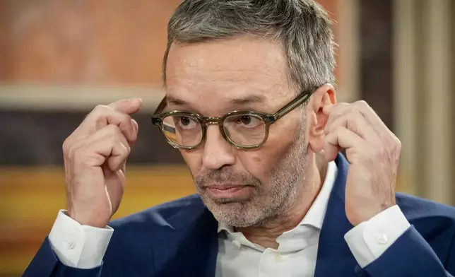 Herbert Kickl, leader of the Freedom Party of Austria adjusts his glasses at the national broadcaster studio, set up in the parliament building, in Vienna, Austria, Sunday, Sept. 29, 2024, after polls closed in the country's national election. (AP Photo/Andreea Alexandru)