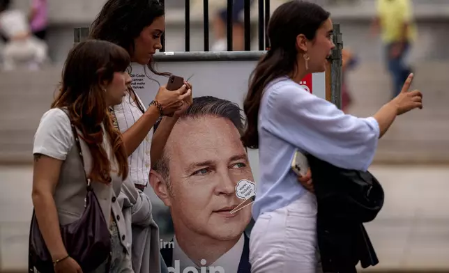 Women walk by posters of the Social Democratic, SPOe Party, showing Andreas Babler, in Vienna, Austria, Thursday, Sept. 26, 2024, ahead of the country's national election which will take place on Sept. 29. (AP Photo/Andreea Alexandru)