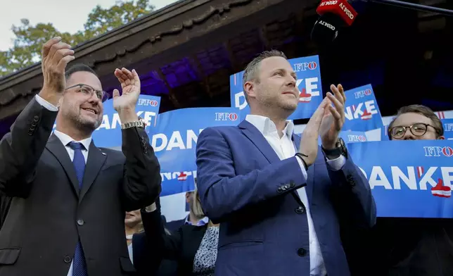 Michael Schnedlitz, right, and Christian Hafenecker of the Freedom Party of Austria cheer at the party headquarters in Vienna, Austria, Sunday, Sept. 29, 2024 upon seeing initial electoral projections. (AP Photo/Heinz-Peter Bader)