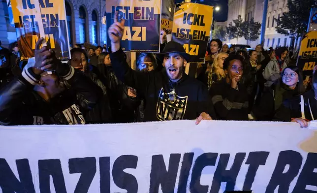 Anti right wing protesters shout slogans holding a banner that reads "Don't let Nazis rule and never let them march" near the parliament building, in Vienna, Austria, Sunday, Sept. 29, 2024, after polls closed in the country's national election. (AP Photo/Andreea Alexandru)