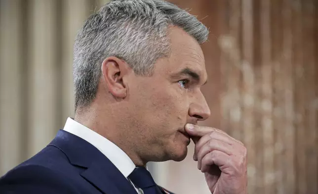 Austrian Chancellor Karl Nehammer gestures at the national broadcaster studio, set up in the parliament building, in Vienna, Austria, Sunday, Sept. 29, 2024, after polls closed in the country's national election. (AP Photo/Heinz-Peter Bader)