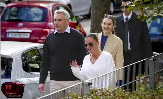 Austrian Chancellor Karl Nehammer and his wife Katharina arrive at a polling station in Vienna, Austria, Sunday, Sept. 29, 2024, to cast their votes in the country's national election. (AP Photo/Heinz-Peter Bader)