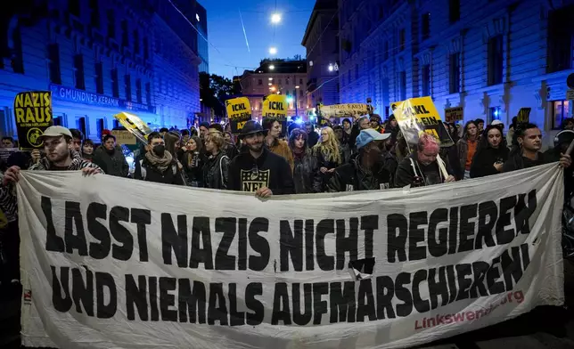 Anti right wing protesters shout slogans holding a banner that reads "Don't let Nazis rule and never let them march" near the parliament building, in Vienna, Austria, Sunday, Sept. 29, 2024, after polls closed in the country's national election. (AP Photo/Andreea Alexandru)