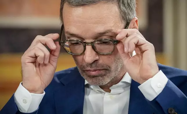 Herbert Kickl, leader of the Freedom Party of Austria adjusts his glasses at the national broadcaster studio, set up in the parliament building, in Vienna, Austria, Sunday, Sept. 29, 2024, after polls closed in the country's national election. (AP Photo/Andreea Alexandru)