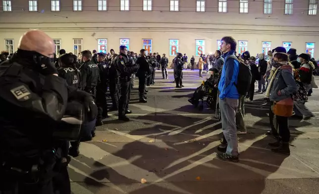 Austrian riot police officers block face anti right wing protesters, in Vienna, Austria, Sunday, Sept. 29, 2024, after polls closed in the country's national election. (AP Photo/Andreea Alexandru)