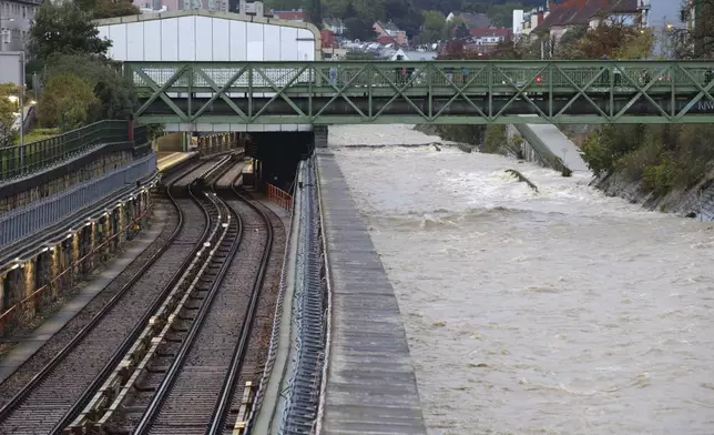 River Wien floods its banks next to tracks and a closed subway station in the west of Vienna, Austria, Sunday, Sept. 15, 2024. (AP Photo/Heinz-Peter Bader)