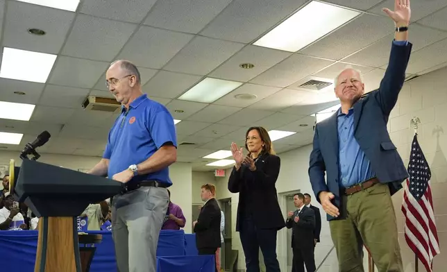 FILE - Shawn Fain, President of the United Auto Workers, left, is joined by Democratic presidential nominee Vice President Kamala Harris, center, and Democratic vice presidential nominee Minnesota Gov. Tim Walz, at a campaign rally at UAW Local 900, August 8, 2024, in Wayne, Mich. (AP Photo/Julia Nikhinson, File)