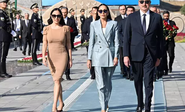 In this photo provided by the Azerbaijan's Presidential Press Office, Azerbaijan's President Ilham Aliyev, his wife and Vice President Mehriban Aliyeva, center, and their daughter Leyla Aliyeva walk to pay tribute to Heydar Aliyev in Tashkent, Uzbekistan, Thursday, Aug. 22, 2024. (Azerbaijani Presidential Press Office via AP)