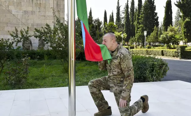 FILE In this photo provided by Azerbaijan's Presidential Press Office on Oct. 15, 2023, Azerbaijani President Ilham Aliyev kisses a national flag in the city of Aghdara, once under Armenian control in former breakaway territory Karabakh, Azerbaijan. (Azerbaijani Presidential Press Office via AP, File)