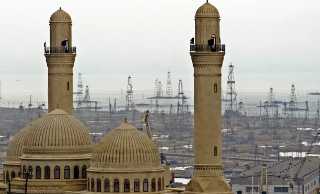 FILE - This file photo shows the Bibi Heybat Mosque with oil derricks in the background in Baku, Azerbaijan, on March 7, 2019. (AP Photo/Mikhail Metzel, File)