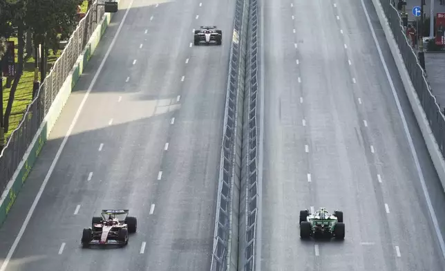 Ferrari driver Carlos Sainz of Spain, left front, drives in front of his teammate Charles Leclerc of Monaco during a Formula One Grand Prix practice in Baku, Azerbaijan, on Friday, Sept. 13, 2024. (AP Photo/Sergei Grits)