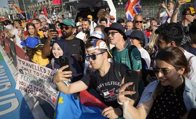 Spectators enjoy a pre-race track walk at the Baku circuit, in Baku, Azerbaijan, Thursday, Sept. 12, 2024. (AP Photo/Sergei Grits)