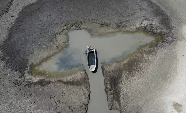 A man collects mud that is used in medical therapy from the Rusanda salty lake that has dried out completely, near Melenci, Serbia, Wednesday, Sept. 4, 2024. Experts say the summer of 2024 in the Balkans was the hottest since measurements started more than 130 years ago. (AP Photo/Darko Vojinovic)