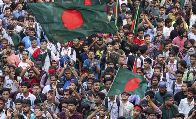 Students and other activists carry Bangladesh's national flag during a protest march organized by Students Against Discrimination to mark one month since former Prime Minister Sheikh Hasina stepped down after a mass uprising, in Dhaka, Bangladesh, Thursday, Sept. 5, 2024. (AP Photo/Rajib Dhar)