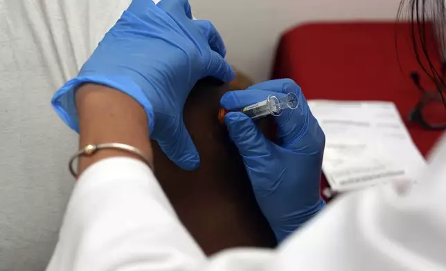 A pharmacist administers a COVID-19 vaccine at a pharmacy in New York, on Tuesday, Sept. 24, 2024. (AP Photo/Mary Conlon)