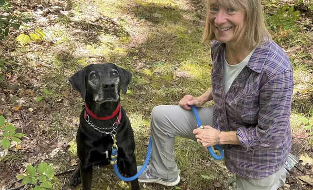 Susannah Johnston, of Croton-on-Hudson, N.Y., poses her dog Ellie on Sept. 8, 2024 in Norfolk, Conn. Johnston, a fit yoga instructor and strength trainer, has been injured three times in incidents involving walking her dog. (Vincent Cohan via AP)