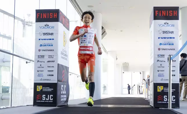 In this photo provided by ISF/Meeting, runner Yuri Yoshizumi crosses the finish line during a race of Stairclimbing World Championships on Nov. 19, 2023 in Osaka, western Japan. (ISF/MEETING via AP)