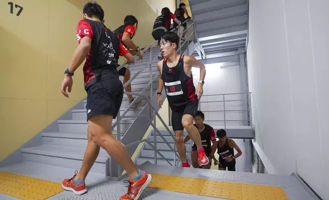 In this photo provided by ISF/Meeting, competitors climb stairs during a race of Stairclimbing World Championships in Osaka, western Japan, on Nov. 19, 2023. (ISF/MEETING via AP)