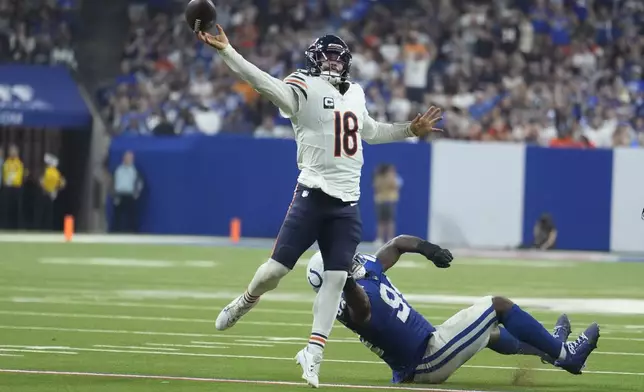 Chicago Bears quarterback Caleb Williams (18) is pressured by Indianapolis Colts defensive end Tyquan Lewis (94) during the second half of an NFL football game Sunday, Sept. 22, 2024, in Indianapolis. (AP Photo/Michael Conroy)