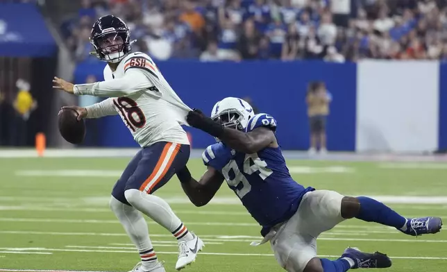 Chicago Bears quarterback Caleb Williams (18) is pressured by Indianapolis Colts defensive end Tyquan Lewis (94) during the second half of an NFL football game Sunday, Sept. 22, 2024, in Indianapolis. (AP Photo/Michael Conroy)