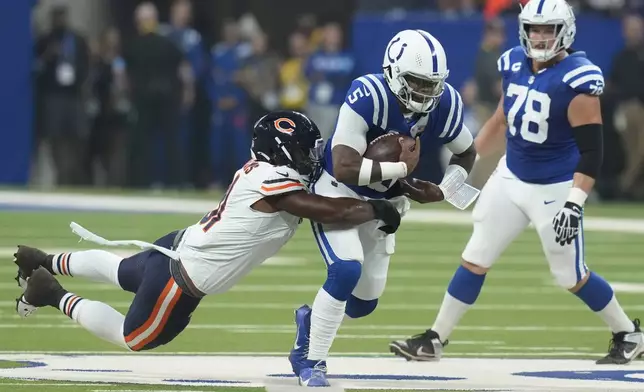 Indianapolis Colts quarterback Anthony Richardson (5) is hit by Chicago Bears defensive tackle Chris Williams (91) during the first half of an NFL football game Sunday, Sept. 22, 2024, in Indianapolis. (AP Photo/Darron Cummings)