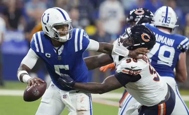 Indianapolis Colts quarterback Anthony Richardson (5) is pressured by Chicago Bears defensive tackle Gervon Dexter Sr. (99) during the first half of an NFL football game Sunday, Sept. 22, 2024, in Indianapolis. (AP Photo/Darron Cummings)