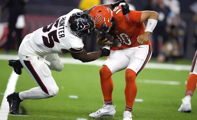 Chicago Bears quarterback Caleb Williams, right, is grabbed by Houston Texans defensive end Danielle Hunter (55) during the second half of an NFL football game Sunday, Sept. 15, 2024, in Houston. (AP Photo/Eric Christian Smith)