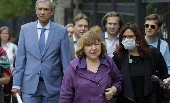 FILE - Svetlana Alexievich, the 2015 Nobel literature laureate, center, and Pavel Latushko, former culture minister and ambassador to France, left, walk amid supporters and journalists on their way to the office of the Belarusian Investigative Committee in Minsk, Belarus, on Aug. 26, 2020. (AP Photo, File)