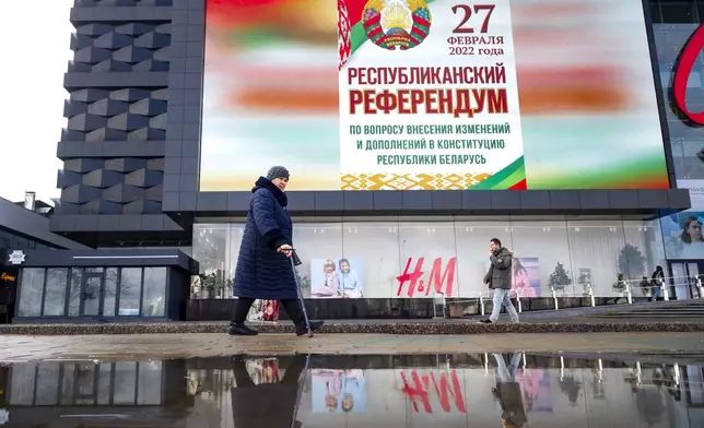 FILE - A woman walks past a poster that reads "Referendum on constitutional amendments" in Minsk, Belarus, on Feb. 18, 2022. (AP Photo, File)