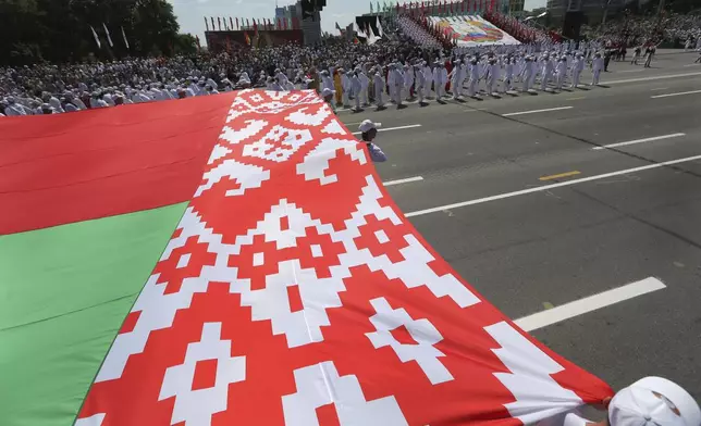 FILE - Belarusian athletes carry the country’s flag during celebrations marking Independence Day in Minsk, Belarus, on July 3, 2013. (AP Photo, File)