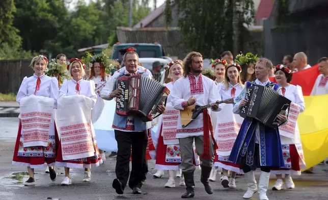 FILE - Belarusians in national costumes walk to the Berezina River in a ritual marking the summer solstice in the village of Parichi, about 200 kilometers (125 miles) southeast of Minsk, Belarus, on July 6, 2022. (AP Photo, File)