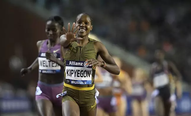 Faith Kipyegon, of Kenya, celebrates after crossing the finish line to win the women's 1500 meters during the Diamond League final 2024 athletics meet in Brussels, Saturday, Sept. 14, 2024. (AP Photo/Frederic Sierakowski)