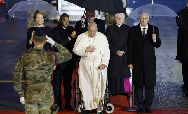 Pope Francis arrives flanked by Queen Mathilde of Belgium and King Philippe of Belgium, at Melsbroek air base in Steenokkerzeel, near Brussels, on the first day of his four-day visit to Luxembourg and Belgium, Thursday, Sept. 26, 2024. (AP Photo/Geert Vanden Wijngaert)