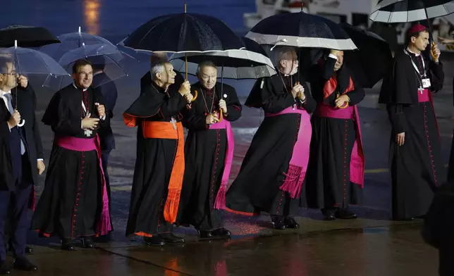 Cardinals wait for Pope Francis upon his arrival at Melsbroek air base in Steenokkerzeel, near Brussels, on the first day of his four-day visit to Luxembourg and Belgium, Thursday, Sept. 26, 2024. (AP Photo/Geert Vanden Wijngaert)