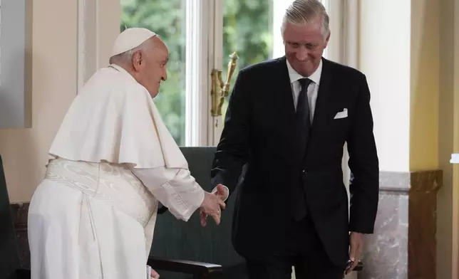 Pope Francis shakes hands with King Philippe during a meeting with the authorities and the civil society in the Grande Galerie of the Castle of Laeken, Brussels, Friday, Sept. 27, 2024. (AP Photo/Andrew Medichini)