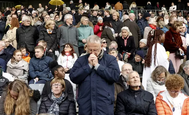 A faithful prays as Pope Francis presides the holy mass , at the King Baudouin stadium in Brussels, Belgium, Sunday, Sept. 29, 2024. (AP Photo/Omar Havana)