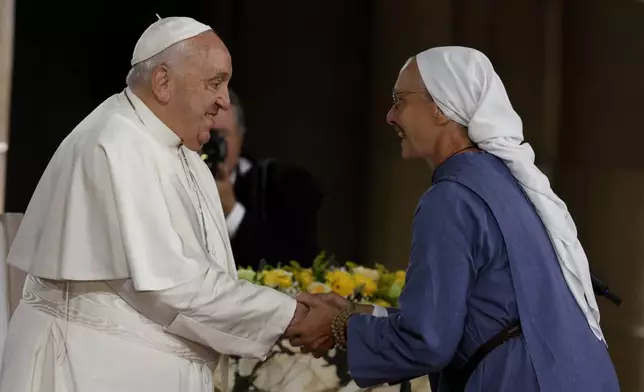 Pope Francis cheers a nun during a meeting with bishops, deacons, and religious people in Koekelberg Basilica of the Sacred Heart, in Koekelberg, Belgium, Saturday Sept. 28, 2024. (AP Photo/Omar Havana)